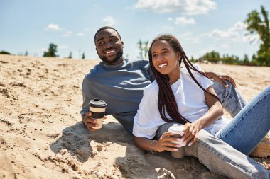 Sevgi dolu bir çift, güneşli bir cadde boyunca el ele yürür. Gülüşlerini ve gülüşlerini paylaşırlar..