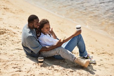Sevgi dolu çiftler su kenarında el ele gezerler, gülümsemelerini paylaşırlar ve birlikte anılar yaratırlar..