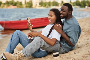 Sevgi dolu bir çift, el ele yürür nehir kenarında, gülücükler ve kahkahalar atar..