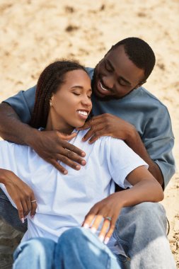 Sevgi dolu bir çift el ele yürür, güzel bir günde gülümsemelerini ve sıcaklıklarını paylaşırlar..