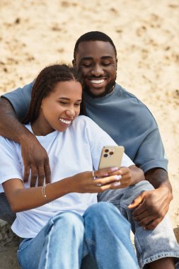 Sevgi dolu bir çift el ele gezer, kahkahalar atar ve güneşin altında tatlı bakışlar atar..