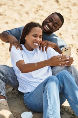 Genç çift sahilde selfie çekerken gülüp eğleniyor..