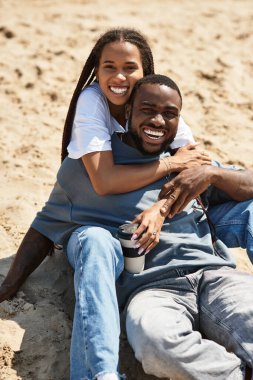Bir çift kumsalda birlikte vakit geçirmekten, gülmekten ve kucaklaşmaktan zevk alır..