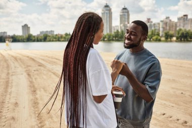 Genç bir çift, neşe dolu bir anın tadını çıkarır. Nehir kenarında yürür, sevgiyi kucaklar..