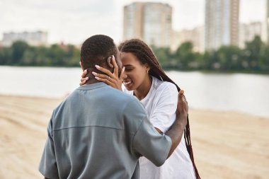 Genç bir çift nehir kenarında el ele yürür, gülüşürler ve aşkla gülerler..
