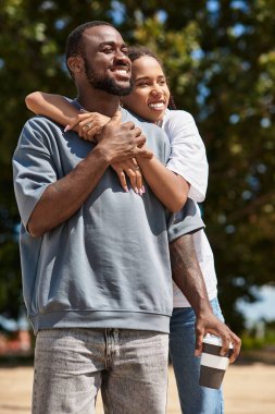 Genç bir çift, aşk ve mutluluğa sarılmış bir şekilde dışarıda yürürken neşeli bir anı paylaşıyor..