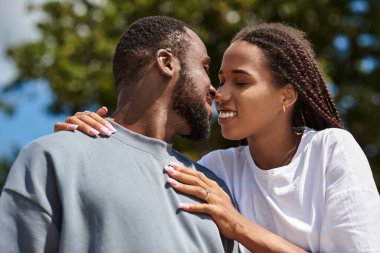 Genç bir çift, hayat dolu bir sokakta el ele yürürken sevgi dolu bir anı paylaşır..