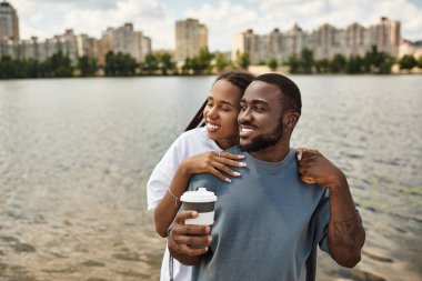 Sevgi dolu bir çift, mavi gökyüzünün altında gülüşlerini ve sıcaklıklarını paylaşıyor..
