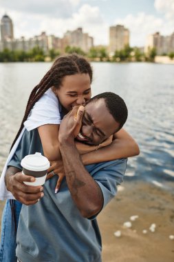 Sevgi dolu bir çift, neşe ve kahkaha dolu suyun yanında yürürken birbirlerine eşlik etmekten zevk alır..