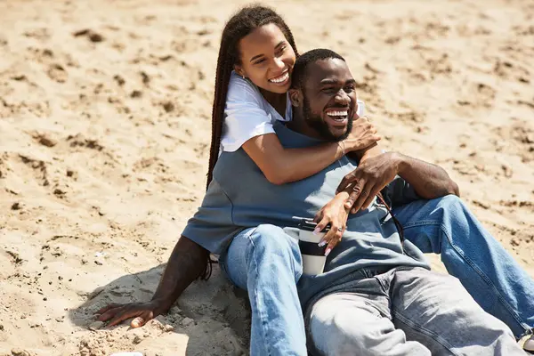 Sevgi dolu bir çift, okyanusun kumlu kıyılarında dinlenirken kahkaha ve sıcaklığı paylaşır..