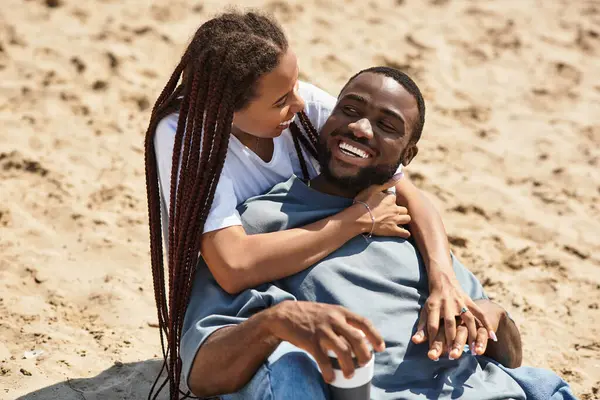 Sevgi dolu bir çift kumsalda yürüyor, gülüyor ve birlikte vakit geçiriyorlar..