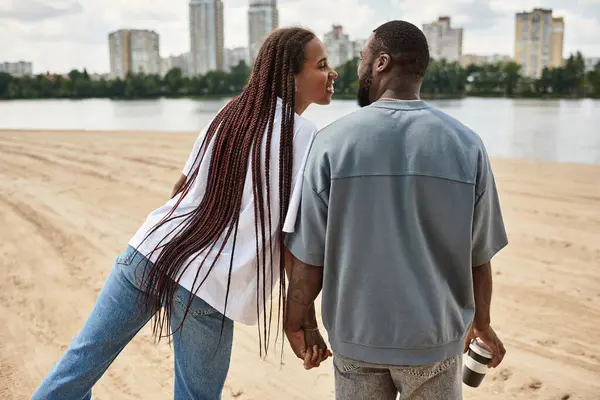 Sevgi dolu eşler el ele yürür, deniz kenarında keyifli anlar paylaşırlar..