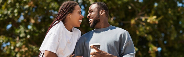 Молодая пара разделяет радостный момент, гуляя вместе под солнцем.