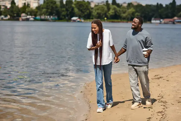 Sevgi dolu çift kumlu göl kenarında el ele yürür, birlikte gülüşür ve kahkahalar atarlar..