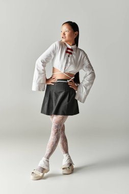 Genç bir Asyalı kadın şık elbisesi ve mavi saçlarıyla şık bir galeri ortamında hava atıyor..