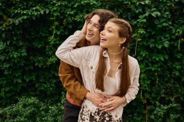 Genç çiftler yemyeşil bir parkta dolaşır, kahkahalar atar ve doğadaki tatlı anları paylaşırlar..