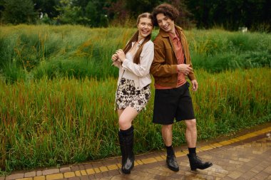 Genç bir çift neşe içinde güzel bir parkta geziniyor, aşkı ve kahkahaları paylaşıyor..