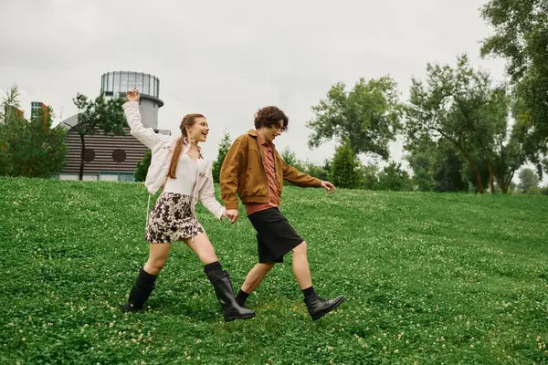 Genç çift, sevgi ve kahkahalarla dolu yemyeşil bir parkta el ele dolaşır..