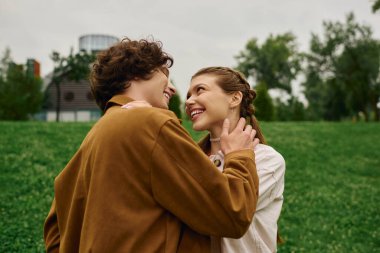 Genç çift yemyeşil bir parkta keyifli bir gezinti yapıyor, birbirlerine derinden bağlanıyorlar..