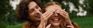 Sevgi dolu çift açık havada, yemyeşil bir parkta, mutlulukla sarmalanmış neşeli bir anı paylaşıyor..