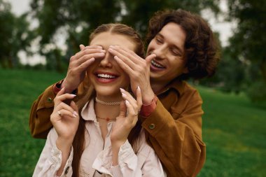 Neşeli genç bir çift gülücüklerle dolu yemyeşil bir parkta gezinirken bağlanır..