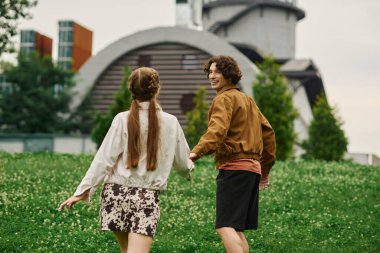 Genç bir çift, neşeli bir parkta birlikte gezer, aşkı ve kahkahaları paylaşır..