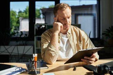 Kendini işine adamış bir işadamı düzenli bir ofis masasında otururken önemli bir işe girişir..