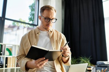 Yakışıklı genç profesyonel bir deftere yazıyor, şık bir çalışma alanında kendini işine adamış..