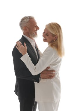 Sevgi dolu üst düzey bir çift birbirine sarılır. Zarif kıyafetleri içinde şefkat ve tarz gösterirler..