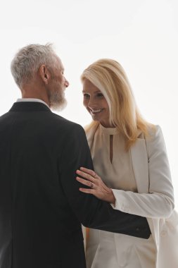 Kibar giyinmiş yaşlı çift sevgi ve neşeyle dolu kalpten bir anın tadını çıkarıyor..