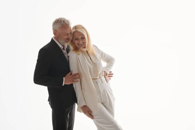 Şık giyimli çift sevgiyle sarılıyor, sevgilerini ve romantik ilişkilerini sergiliyor..