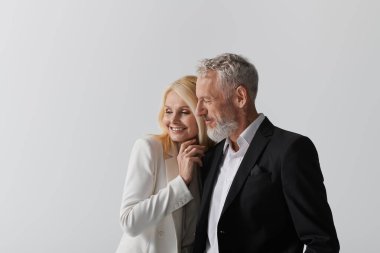 Şık giyinmiş neşeli bir son sınıf çifti sevgi ve bağ dolu bir anı kucaklıyor..