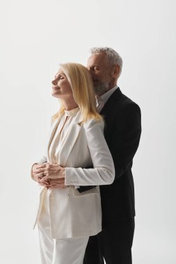 Çekici bir son sınıf çifti, şık elbiseleriyle sevgi ve zarafet saçarak bir arada durur..