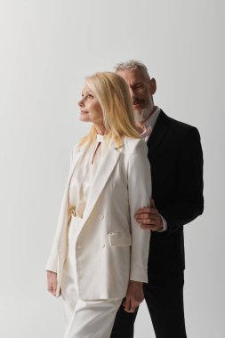 Sadık bir son sınıf çifti, şık ve şık kıyafetler giyerken romantizm ve zarafet saçar..