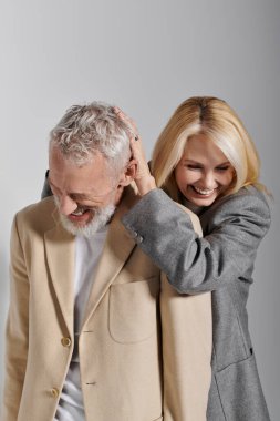 Şık giyinmiş neşeli bir son sınıf çifti birlikte mutlu bir anı paylaşıyor..