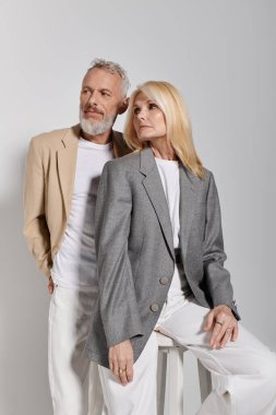 Şık son sınıf çifti, benzersiz moda kıyafetlerine sıcaklık ve zarafet katıyor..