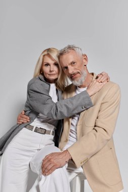 Üst düzey bir çift, aşklarını ve tarzlarını gösteren zarif kıyafetler giyip sıcak bir şekilde kucaklaşır..