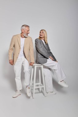 Kibar giyinmiş üst düzey bir çift, aşklarını ve ilişkilerini göstererek gülüşlerini paylaşıyor..