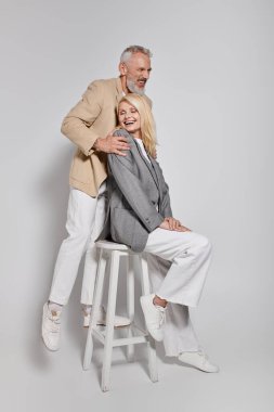 Şık giysiler içinde, neşeli bir anın tadını çıkartan son sınıf aşığı bir çift.