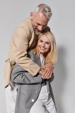 Neşeli yaşlılar birbirlerini kucaklıyor, şık kıyafetlerini ve derin bağlantılarını sergiliyorlar..