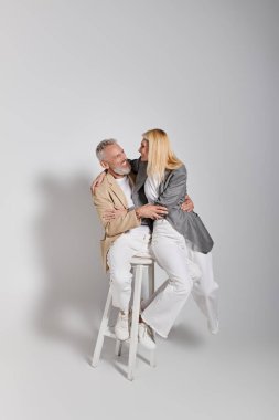 Neşeli yaşlı çift, modaya uygun tarzlarını ve aşklarını sergileyerek birlikte sıcak bir anı paylaşıyor..