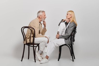 Çekici bir üst sınıf çifti modern kıyafetlerini giyerken yürekten sohbete dalarlar..