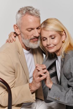 Sevgi dolu yaşlı çift, şık giyinirken sıcak bir sevgi gösterisi yapar..