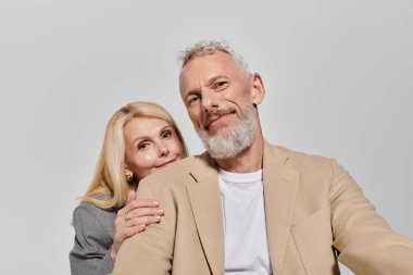 Şık giyinmiş, sevgi dolu yaşlı bir çift sıcak bir anı paylaşır, neşe ve bağ yayar..