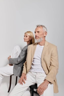 Üst düzey çiftler, modaya uygun kıyafetler giyip, basit bir arka plana karşı sıcaklık saçıyorlar..