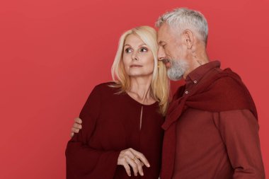 Sevgi dolu üst düzey bir çift, şık kıyafetlerini ve derin sevgilerini göstererek sıcak bir şekilde kucaklaşır..