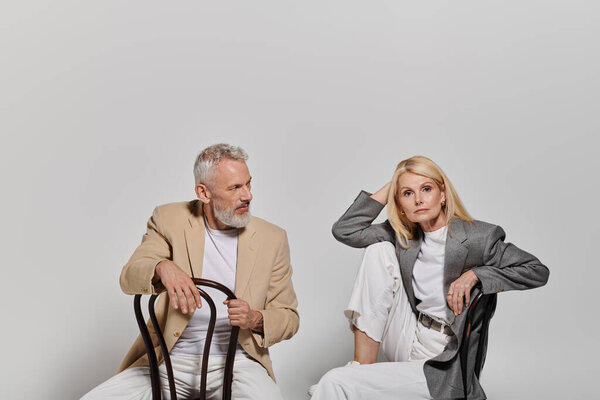 A loving couple dressed in fashionable outfits showcases their deep bond and style with grace.