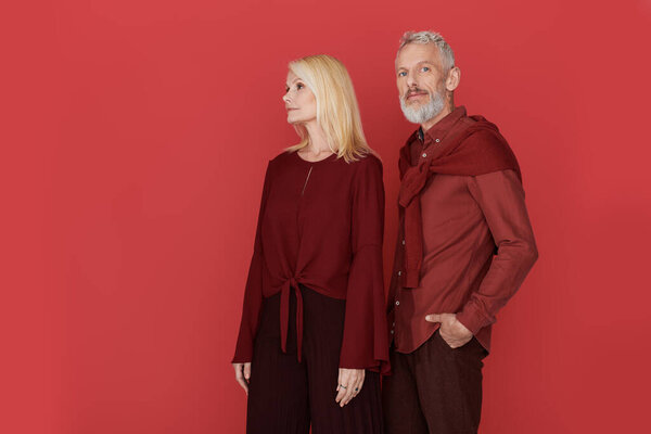 A stylish senior couple showcases their love while dressed in chic outfits and posing gracefully.