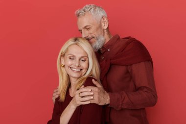 Üst düzey bir çift neşeyle kucaklaşır, şık kıyafetler giyer, sevgi ve mutluluk saçar..