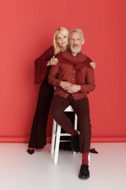 Üst düzey bir çift birbirlerine sarılıyor, şık kıyafetlerini ve derin sevgilerini sergiliyorlar..